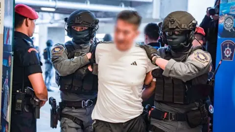 She Zhijiang, Accused Scammer, Extradited from Thailand to China