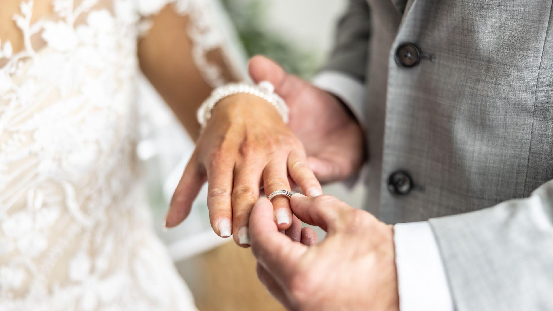 A man places a ring on a bride’s finger