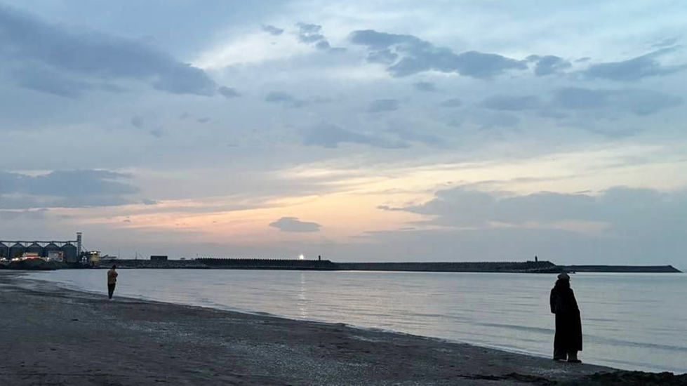 A woman stands on a Caspian Sea beach in Iran.