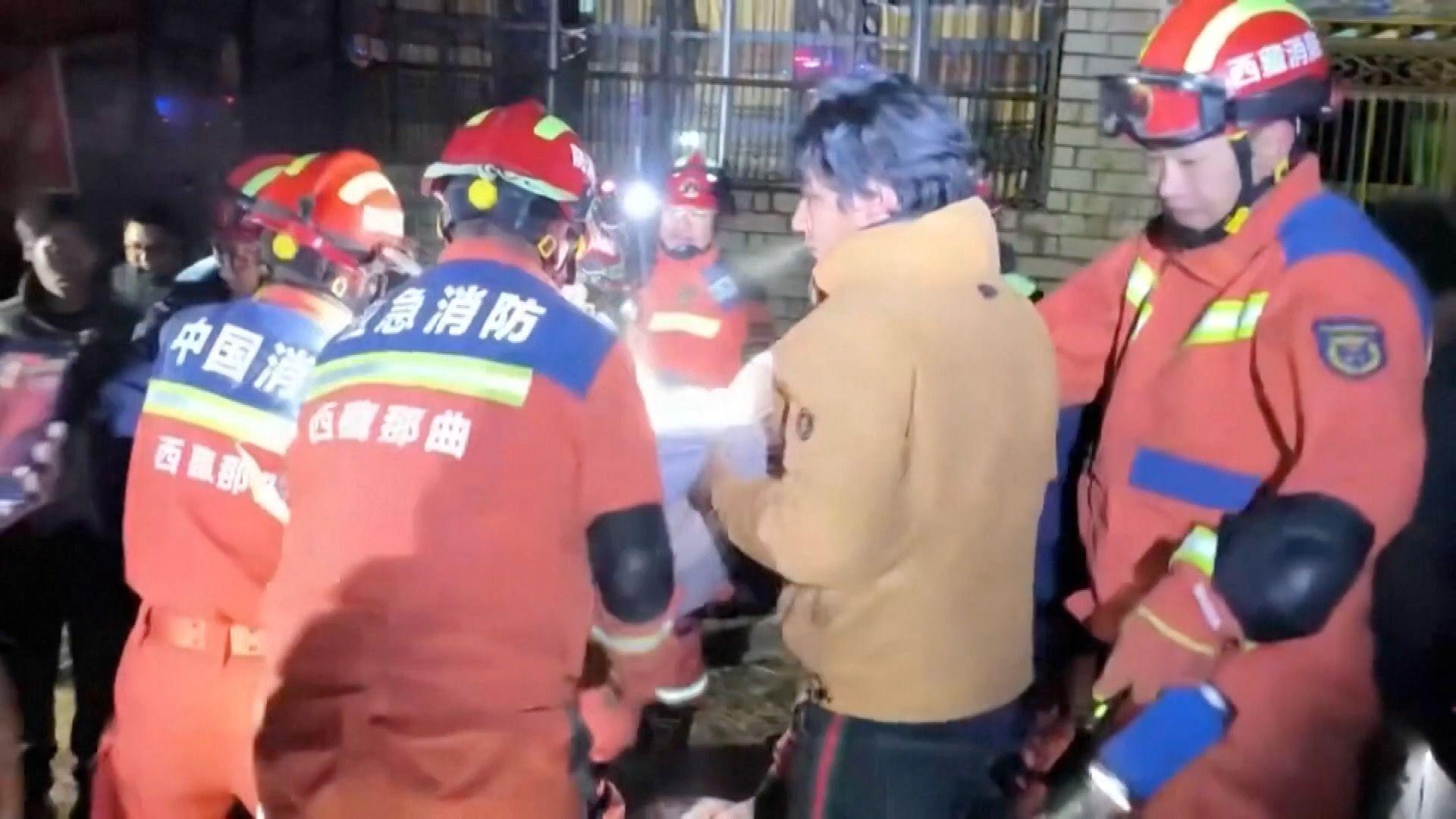 Firefighters helping residents after the quake in Baqên
